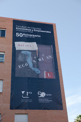 Facultad de Ciencias Económicas y Empresariales con cartel Conmemorativo del 50 Aniversario. Camp...