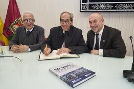 José Manuel González Páramo firma el libro de visitas de la Facultad de Económicas tras la presen...