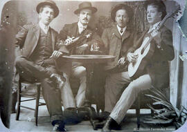 Retrato de un grupo de amigos en una taberna, uno de ellos con una guitarra. Fotógrafo desconocido.