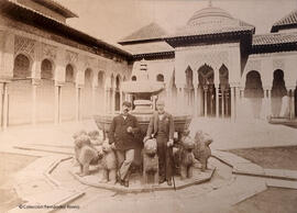 Granada, Alhambra, Patio de los Leones con dos hombres apoyados en los leones de la fuente. Fotógrafo desconocido.