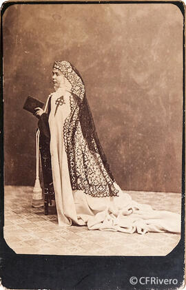 España, retrato de una jóven monja con mantilla y capa de la Orden de Santiago, en un reclinatorio con un libro en las manos. Fotógrafo desconocido.