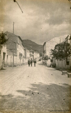 Béznar (Lecrín, Granada), calle principal, carretera de Granada a Motril, con tres transeuntes. Fotógrafo desconocido.