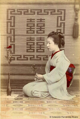 Japón, joven japonesa sosteniendo una flor. Ueno Hikoma