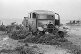 Vehículo del sanatorio Francisco Franco en la playa de La Caleta, embarrada por las inundaciones ...