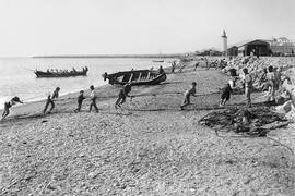 Playas de la Malagueta. Pescadores arrastrando las redes del copo en la orilla del mar. Málaga, E...